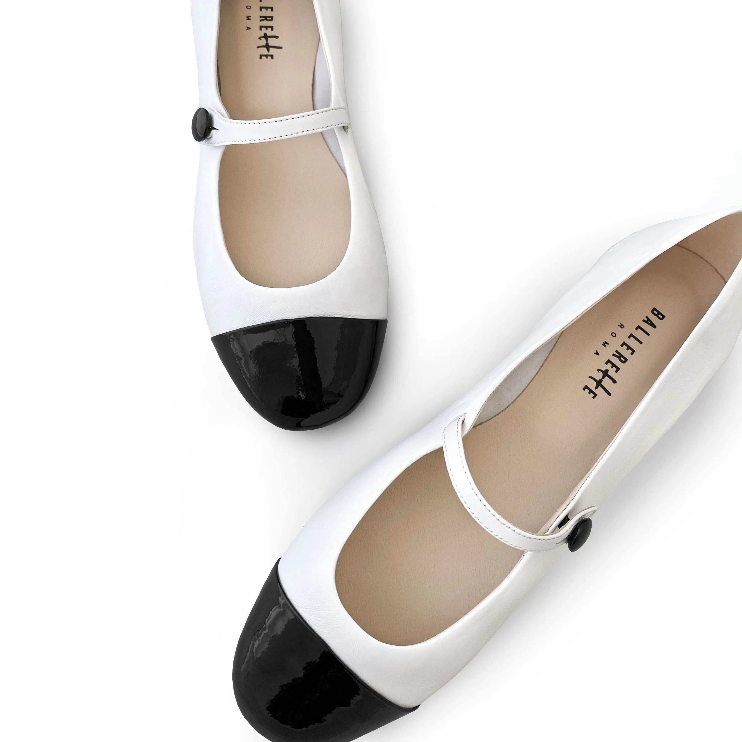 White ballet flats with black patent toe and strap