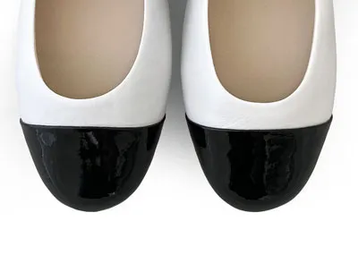 White ballet flats with black patent toe and strap