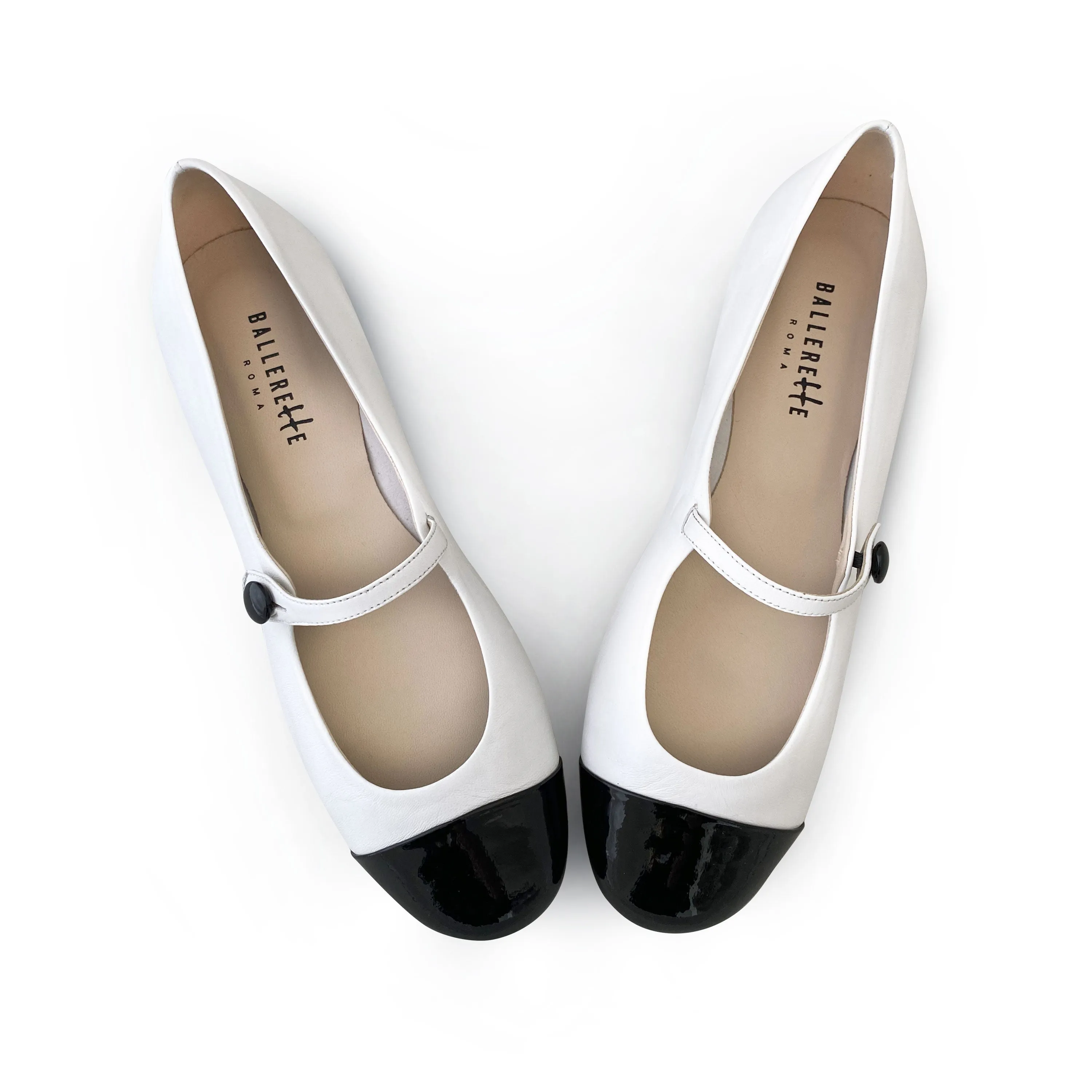 White ballet flats with black patent toe and strap