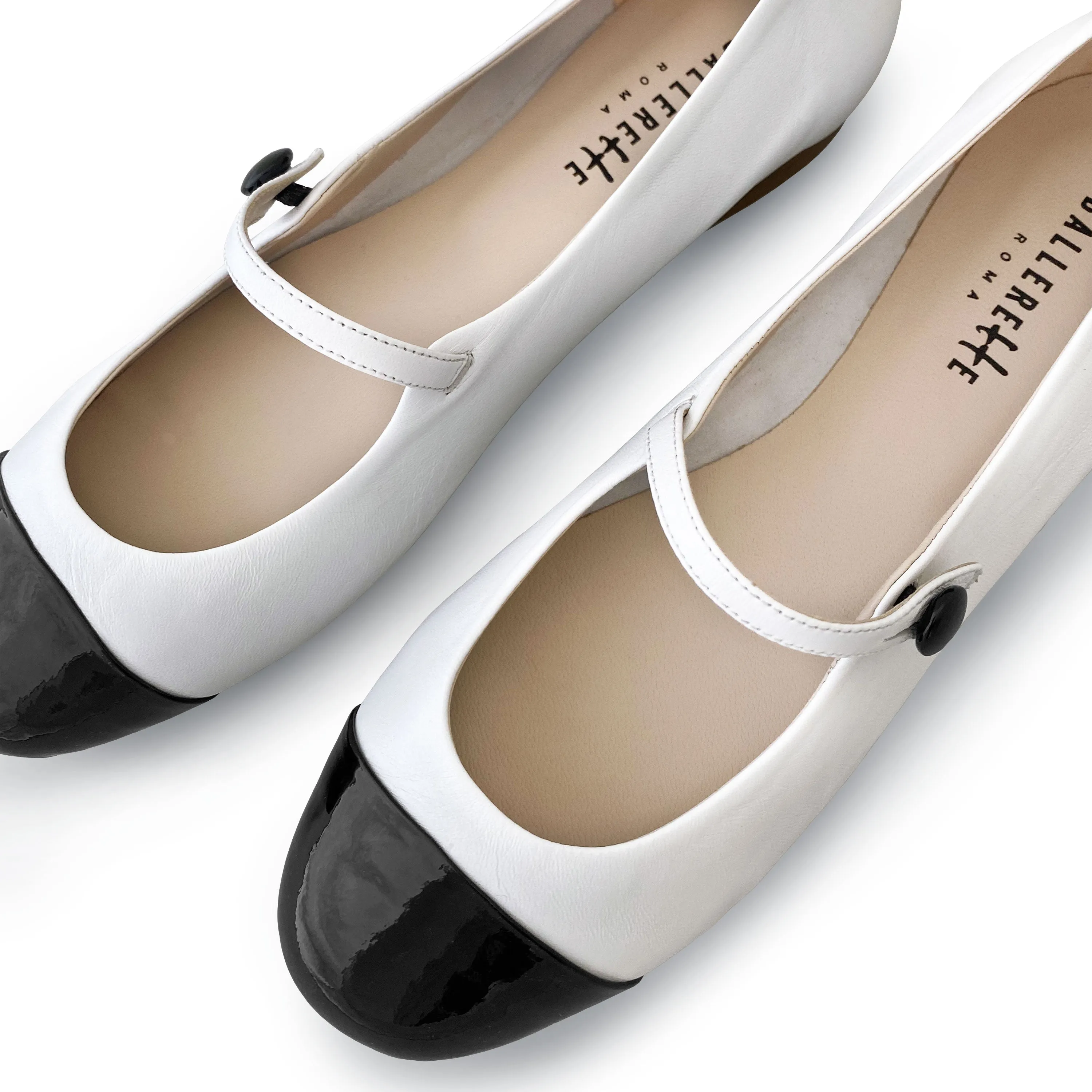 White ballet flats with black patent toe and strap